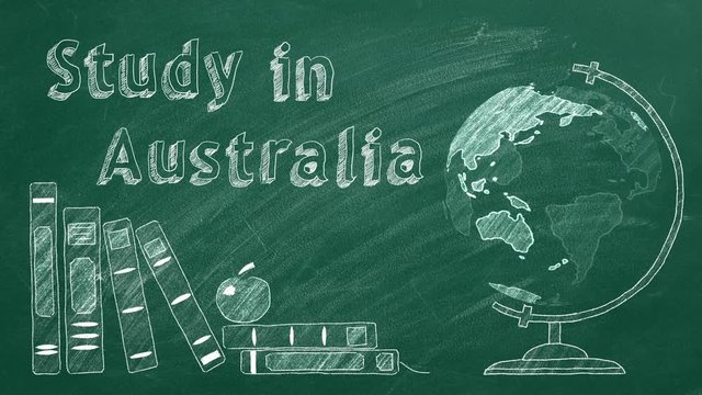 Lettering "Study in Australia", rotating globe and school books are drawn with chalk on a blackboard. Study abroad concept.