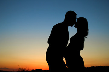 Fototapeta na wymiar silhouette of a pregnant couple in love