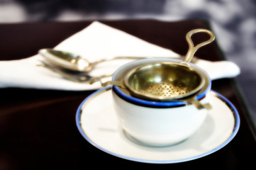 old white porcelain cup with strainer for tea infusion