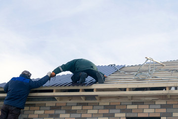 workers build the roof of a new house
