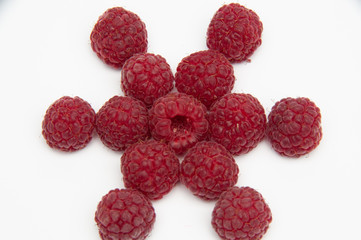 Star from red raspberries, photo from above on a white background