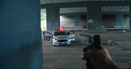 Shootout between police and criminals. Close-up dangerous offender shooting at police car and...