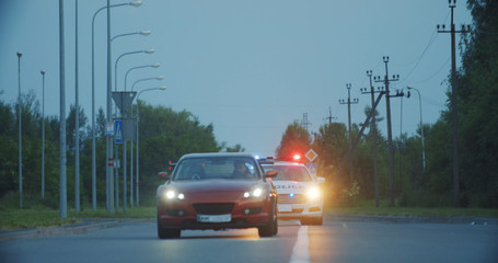 View of self-willed young man driving on modern sports car from the police. Police officer cop...