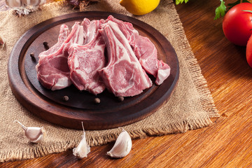 Raw fresh lamb chops on wooden cutting board