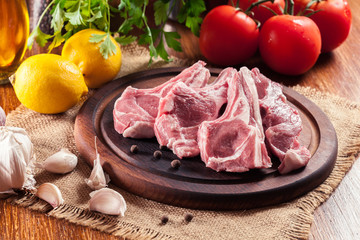 Raw fresh lamb chops on wooden cutting board