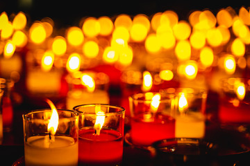 Lit Prayer Candles Close Up in Black Background. Hope and Successful Concept.