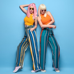 Two fashionable girl with stylish hair. Beautiful Adorable young woman in summer colorful outfit,...