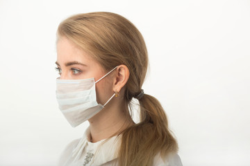 beautiful young woman in medical mask on a white background