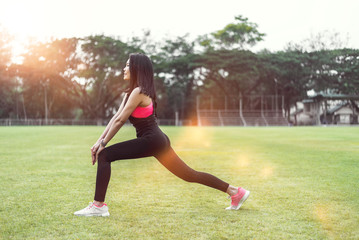 Women warm up before exercising outdoors during the morning hours in the park.