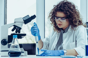 Young scientist working at the lab. Young female scientist doing some research.