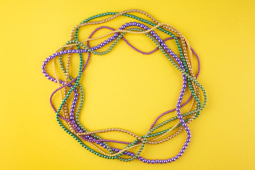Mardi Gras beads background with place for text. Top view