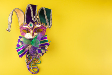 A festive, colorful mardi gras or carnivale mask on a yellow background. Venetian masks.