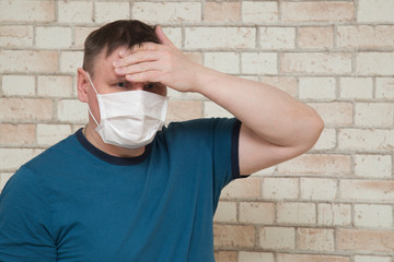 Coronavirus.A masked man against a brick wall.