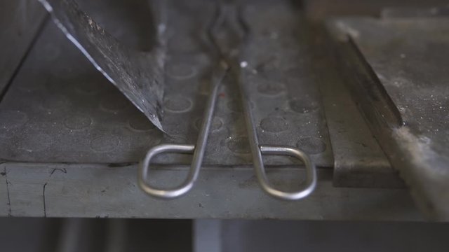 Special laboratory tool for holding high temperature objects on a metal table. 4k Follow the focus.