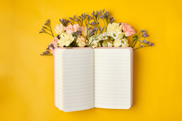 Pink Notepad with Flowers over yellow background. Spring mood