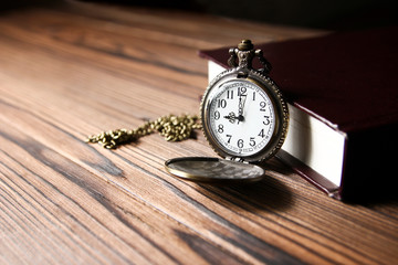 a pocket watch with book background