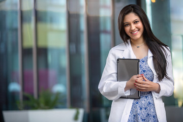 Commercial portrait of an indian american medical staff worker, smiling cheerful at dental health offices