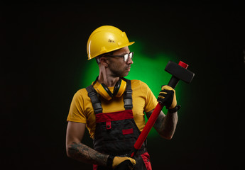 the male construction worker with a sledgehammer - obrazy, fototapety, plakaty