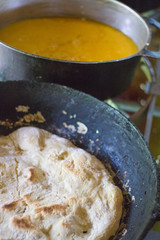 Close-up of cooking eggs and bread in cast iron pans