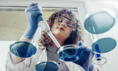 Young scientist working at the lab. Young female scientist doing some research.
