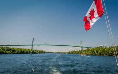 Fototapeta premium Boating under Canadian flag through the waterway of Thousand islands