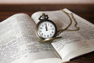 a pocket watch with book background