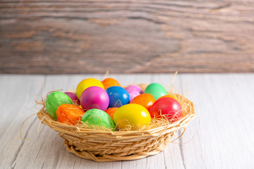 Fototapeta na wymiar Beautiful group Easter eggs in the spring of easter day, red eggs, blue, purple and yellow in Wooden basket on the table background wood