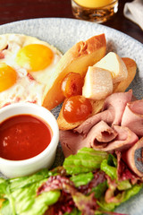 English breakfast including egg , french fries, salad, toasts and sauce.