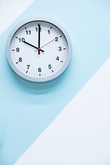 minimalistic white wall clock with light metal on a blue white background. time concept.Theme of Working business time .The concept of The time is going on. geometric background. Time is running out