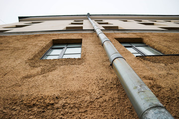 Old house facade with metal drainpipe