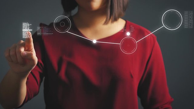 Woman draws a digital connection network in a futuristic hologram with her finger
