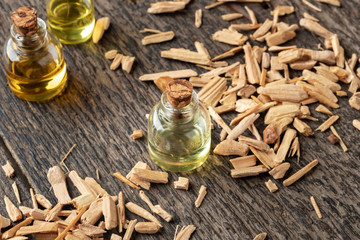 A bottle of cedar essential oil with pieces of cedar wood