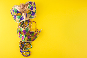 A festive, colorful mardi gras or carnivale mask on a yellow background. Venetian masks. © vetre