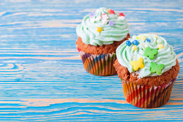 Colorful cupcakes on a white wooden background