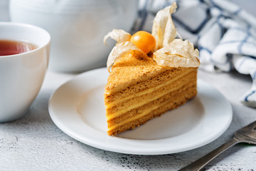 Honey cake with caramel cream filling decorated with physalis