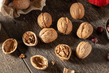 Whole and broken walnuts on a wooden table