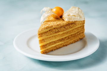 Honey cake with caramel cream filling decorated with physalis