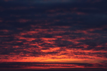 Obraz premium Crimson sky with clouds illuminated by the sun at sunset or sunrise at dusk