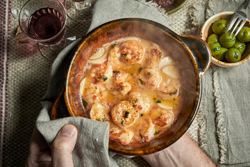 Chef serving a dish of scampi in savory sauce
