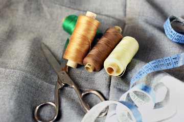 Fototapeta na wymiar Sewing. Spools of thread on the fabric. Threads. Meter and scissors