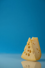 A piece of cheese and a blue background
