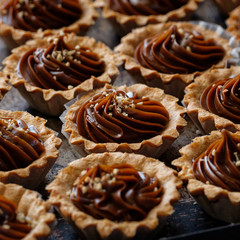Cake with caramel and nuts, sweet dessert closeup. Delicious homemade dessert with condensed milk sauce, closeup. Top view. Sweet food concept.