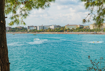 Fototapeta na wymiar Turquoise mediterranean sea, Turkey. Defocused background with beach and hotels view. Color image and copy space.