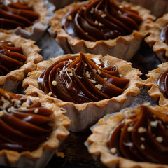 Cake with caramel and nuts, sweet dessert closeup. Delicious homemade dessert with condensed milk sauce, closeup. Top view. Sweet food concept.