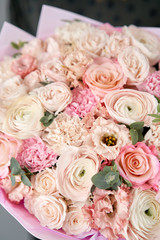 European floral shop. Beautiful bouquet of mixed flowers in womans hands. the work of the florist at a flower shop. Delivery fresh cut flower.