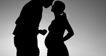 silhouette of a pregnant couple in love