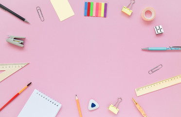 Stationary, back to school,creativity and education concept. Notebook, pen, pencil, eraser, ruler, paper clips, stapler, brush on pink background, flat lay. Top view