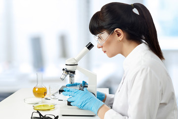 A young female laboratory assistant in a white uniform