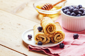 Stack of pancakes with blueberries and honey syrup.