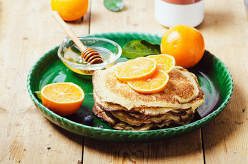 Stack of pancakes with blueberries and honey syrup.